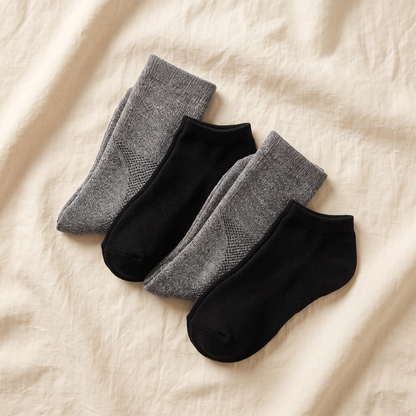 Trail Bundle flat lay - 2 hiking crew and 2 trail ankle pairs folded on cream linen