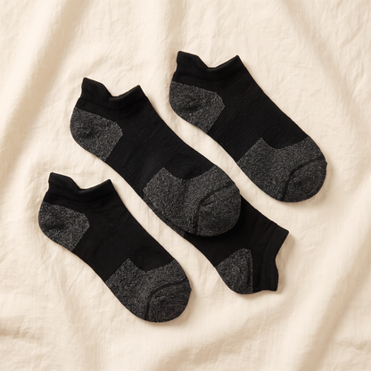 No-Show Bundle flat lay - 4 pairs of black alpaca no-show socks folded on cream linen